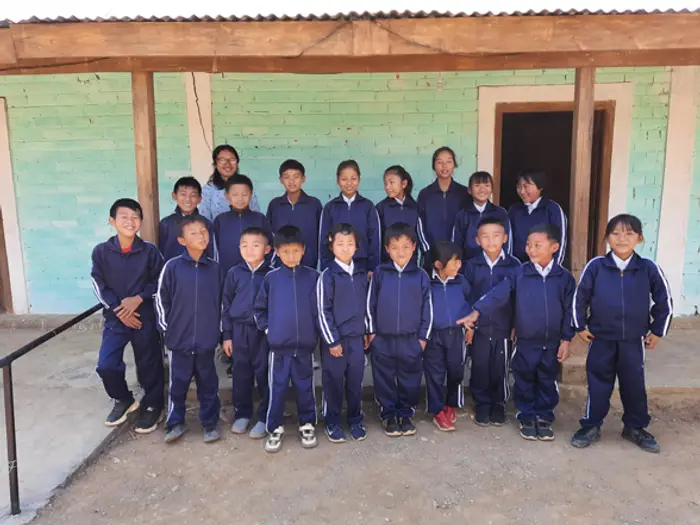 Students in navy uniforms lined up outside the Educere Learning Center, Educere Learning Center