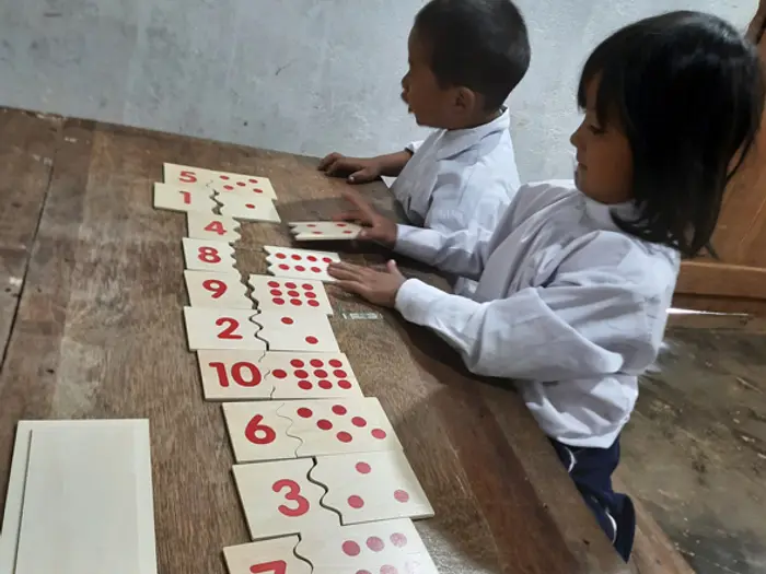 Two children matching number and dot cards on a table, Educere Learning Center