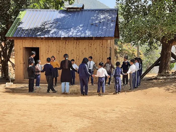 Students and teachers gathered outside the schoolhouse, Educere Learning Center