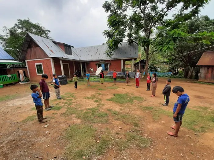 Children playing on the grounds in front of the Educere Learning Center schoolhouse, Educere Learning Center