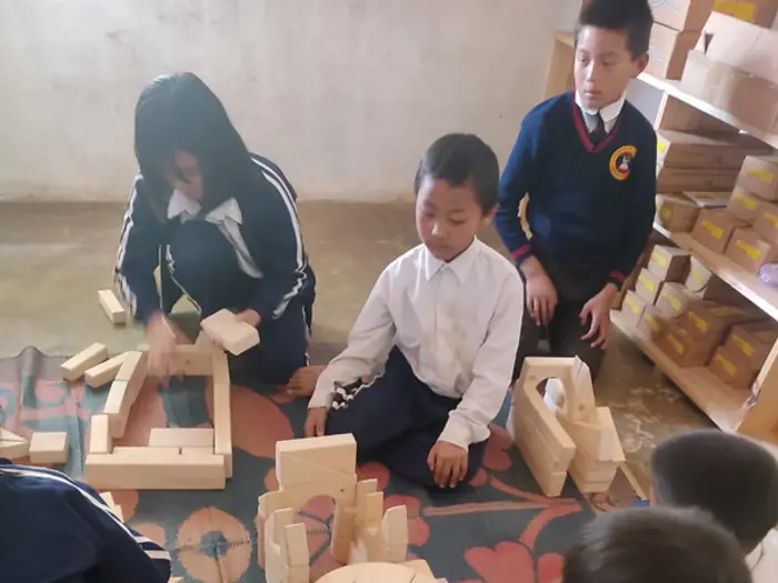 Students building together with wooden blocks, Educere Learning Center