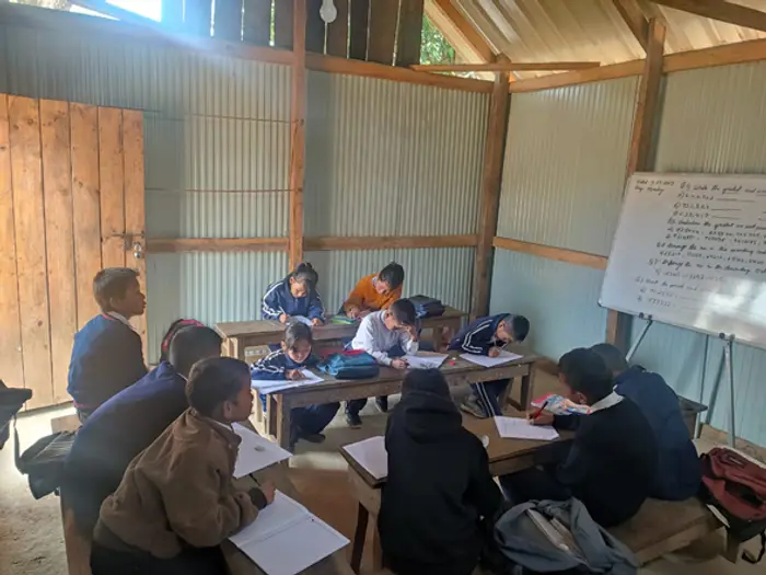 A full classroom of students writing at their desks, Educere Learning Center