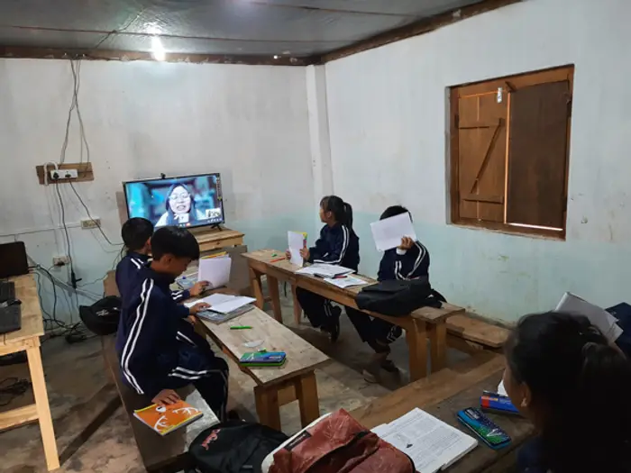 Students at desks watching a lesson on a screen in the classroom, Educere Learning Center